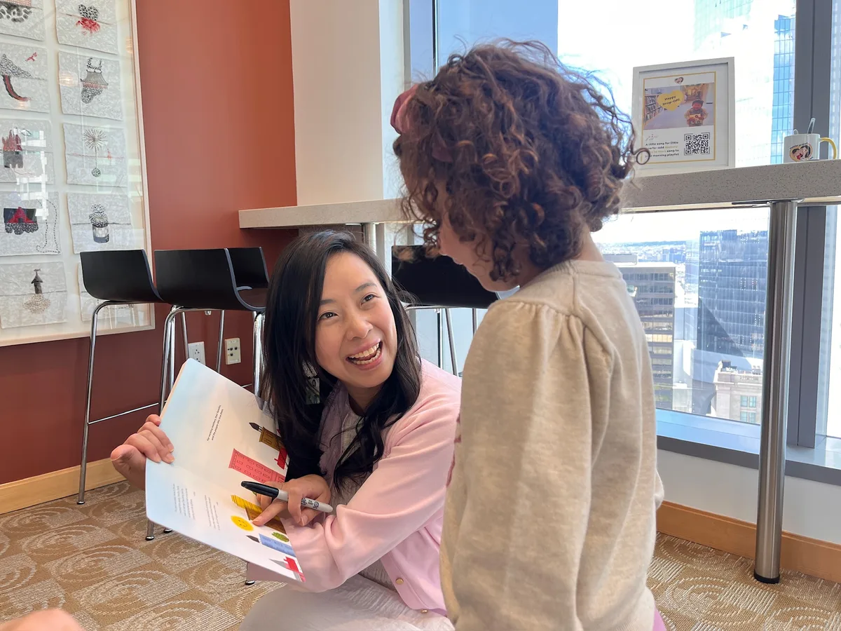 Jossy signing a book for a child