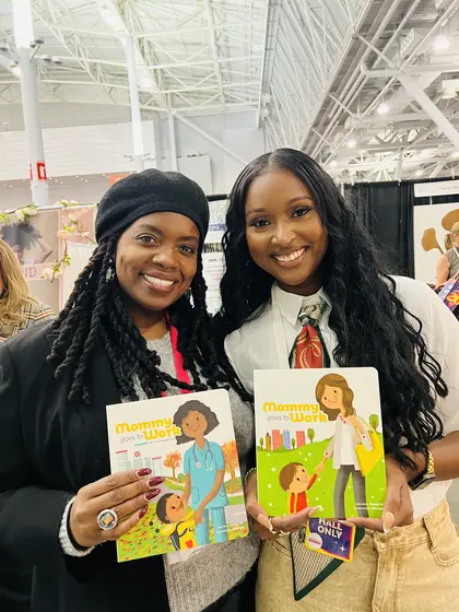 Two women holding the books at an event