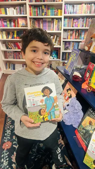 A boy holding the book in a bookstore