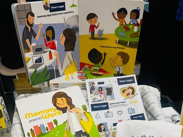 The book open beside a sticker sheet of the story's characters, with a company logo among them