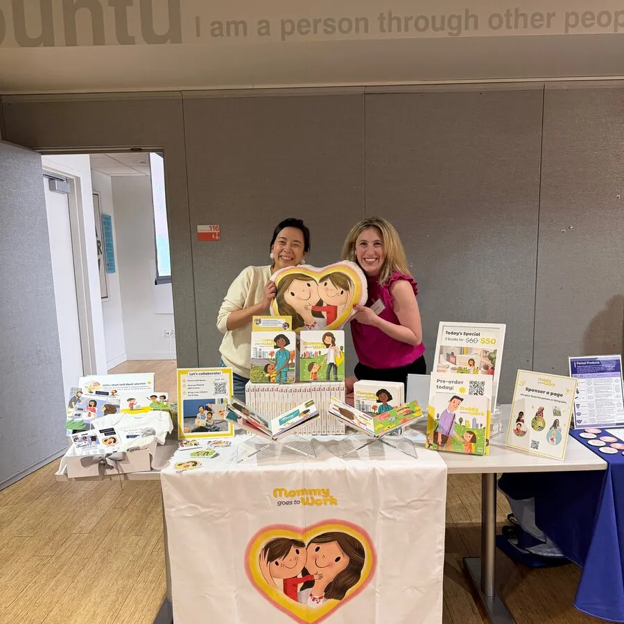 The full collection laid out on a stall table at a company event, two of the team behind it