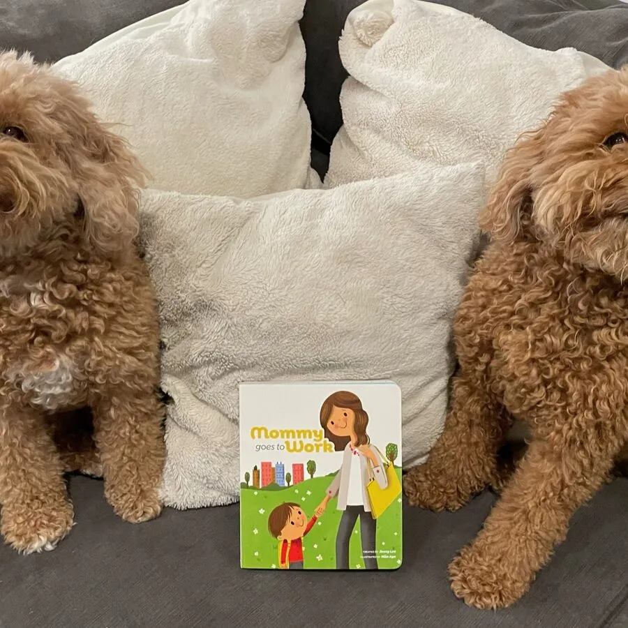 The book propped between two sleeping dogs on a sofa